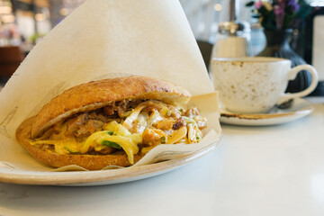 Pita Doner Kebab shawarma sandwich- grilled chicken meat and vegetables in bread on the table in...