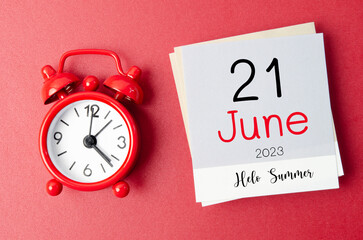 The Hello Summer on 21st June 2023 calendar and alarm clock on red background.