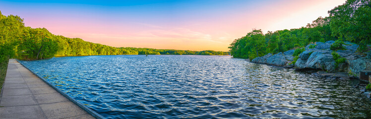 Sunset over the lake. Tranquil woodland landscape over Olney Pond at lincoln Woods State Park Beach...