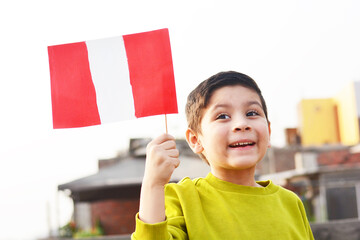 Happy little boy holding peruvian flag.