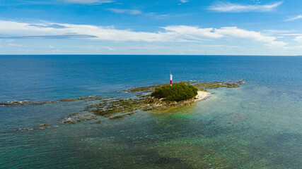 Aerial view of rocky island with a lighthouse in the blue sea. Borneo, Malaysia.