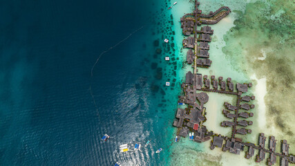 Island Mabul in the blue sea with a coral reef and the beach view from above. Semporna, Sabah, Malaysia.