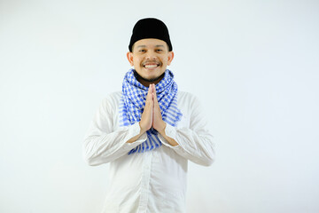 Handsome Moslem Asian man smiling while doing hand praying gesture. Ramadan or ied concepts.