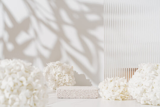Cosmetics skin care product presentation scene made with empty pumice stone podium and white flowers on bathroom shelf. Studio photography.