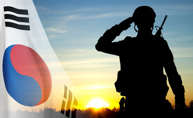 Silhouette of a soldier on background of sunset and flag of South Korea