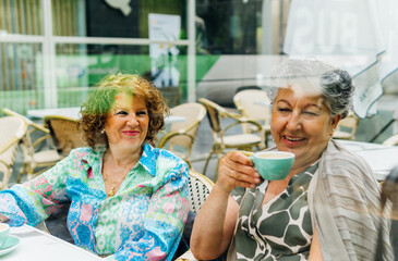 Aged women enjoying a coffee together in an outdoor cafeteria
