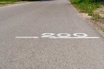 The number two hundred written in white paint on the road