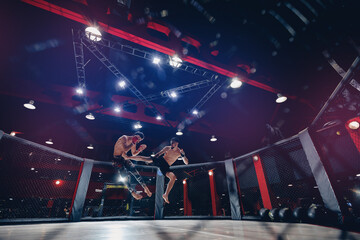 Two man MMA boxers fighters in fights without rules in ring octagon, dark background, motion blur - obrazy, fototapety, plakaty