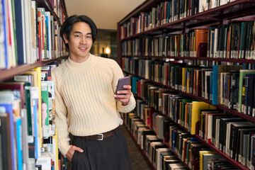 Stylish Japanese university student holding mobile phone and looking camera