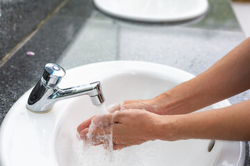 Washing hands in water running.