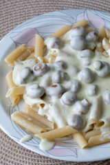 Macaroni in a creamy sauce with champignons and grated cheese