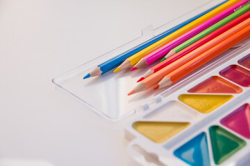 Naklejka premium Composition with school accessories for painting and drawing.Drawing supplies: assorted color pencils, watercolor paints.copy space