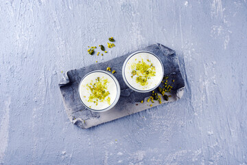 Traditional Indian lime lassi drink with dahi yogurt, lime and chopped pistachios served as top...