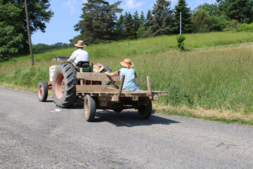 Paysan d'autrefois sur le tracteur, champ et ciel bleu en arrière plan, paysage agriculture et terroir de France authentique