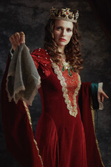 medieval queen in red dress with handkerchief and crown