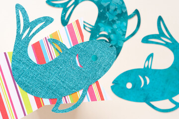 overlapping machine-cut generic fish-shapes and striped scrapbook paper shape