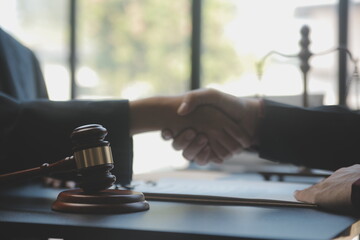 Justice and law concept.Male judge in a courtroom with the gavel, working with, computer and docking keyboard, eyeglasses, on table in morning light