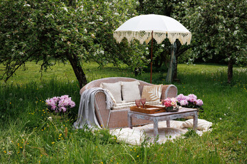 A romantic date for lovers, a picnic in the spring garden, a wedding. A sofa with pillows and a...