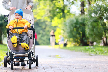autumn walk child in a stroller, street outdoor city landscape