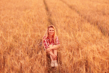 romantic girl posing in a summer field dress