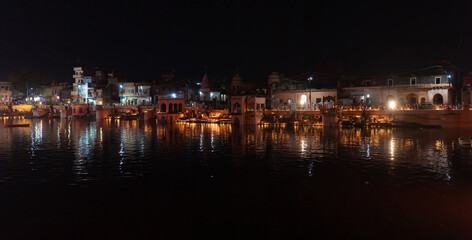 general night view, sacred place on govardhan hill in india, place of pilgrimage, shrine of believers, manasi ganga lake, people light fire lamps