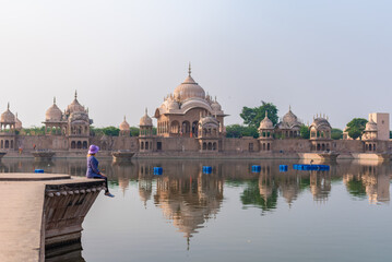 Obraz premium general view, sacred place kusum sarovar on govardhan hill, temple in india, place of pilgrimage, girl on the background of the shrine