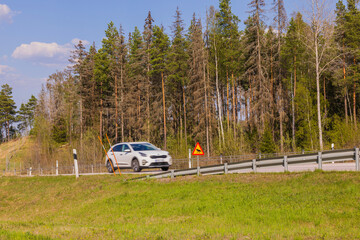 Plakat Beautiful of wildlife warning sign on side of highway with speeding car out of focus. Sweden.
