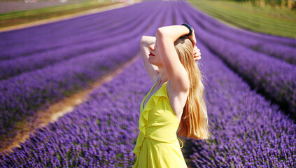portrait of a young blonde girl in a lavender field in the summer at sunset