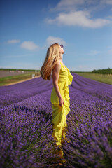 portrait of a young blonde girl in a lavender field in the summer at sunset