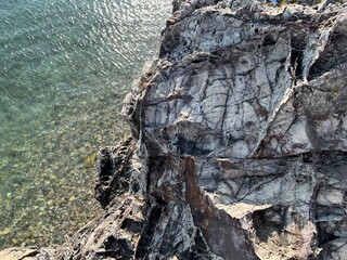 Grey rocky stone surface near the blue sea water