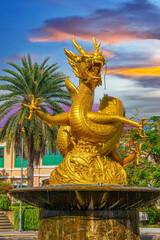 Fototapeta premium Golden dragon in old phuket town phuket Thailand this dragon is on the middle of a big water pond and fountain Chinese Dragon