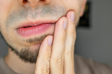 middle aged man feeling hurt from toothache symptom. Dental problems. pressing sore cheek,...