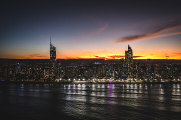 Fototapeta premium Golden Horizon: A Mesmerizing Aerial Sunset View of Surfers Paradise's Downtown Skyscrapers Embracing the Ocean