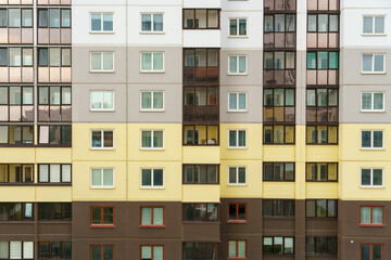 Modern residential multi-storey building. Windows and balconies on a new residential building close-up. Buying and selling apartments, rental housing, happy family life in a comfortable apartment.