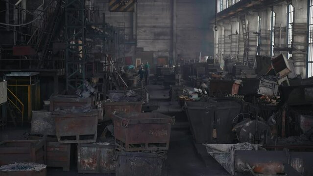 Large view of industrial and household scrap metal in a warehouse. Hunks of metal at the recycling site. Span inside a large warehouse with metal blanks.