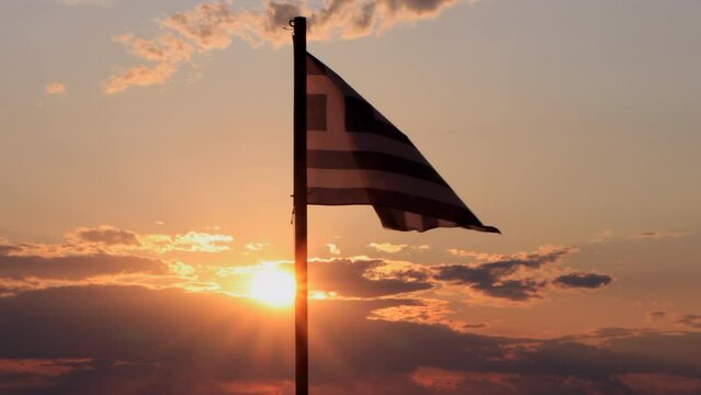 Greek flag waiving against the sunset on the Halkidiki peninsula. Holidays and tourism in Greece.