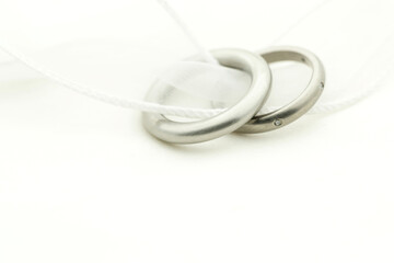 Naklejka premium Close up of wedding rings on white band with copy space on white fabric Focus on rings