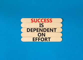 Success and effort symbol. Concept words Success is dependent on effort on wooden stick. Beautiful blue table blue background. Business success and effort concept. Copy space.