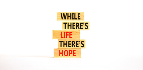 Life and hope symbol. Concept word While there is life there is hope on wooden block. Beautiful white table white background. Business lifestyle life and hope concept. Copy space.