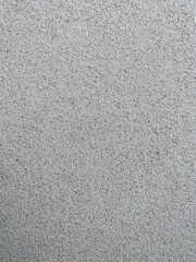 Textured plaster, white with black in the form of small stones, used as a background, side view, texture