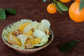 Orange salad with orange fruit, romaine lettuce and walnut nuts. Fresh, homemade salad.