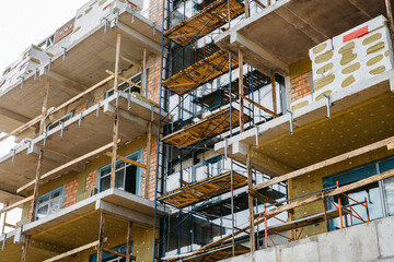scaffolding on the facade of a house under construction with building materials