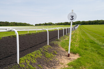 British racecourse field seen next to a 3 furlong marker. The gallops reach the top of the hill....