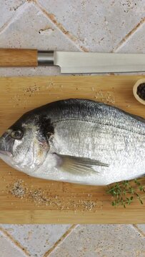 daurade enti&egrave;re, en gros plan, sur une planche &agrave; d&eacute;couper	