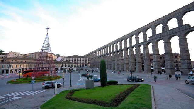 SEGOVIA, Spain - November 13 2022: Panoramic view of Oriental Plaza in the center of Segovia, at sunset. View of antique aqueduct of Segovia. The square decorated for Christmas. Stabilized. Pan right