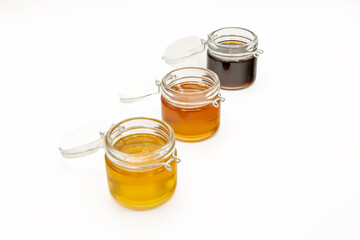 Jars with three different types of honey isolated on a white background