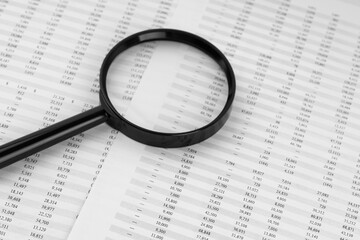 Magnifying glass on financial statement.
