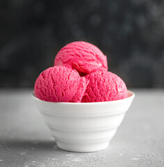 Strawberry ice cream in a white cup on a gray background