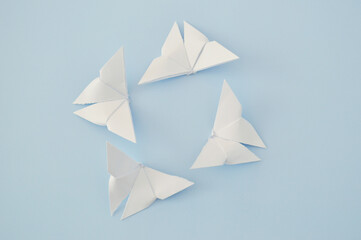White paper origami butterfly on blue background. World Day of Peace. Day Against Humiliation. International Day Of Human Fraternity. International Day of Living Together in Peace