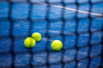 Blue paddle court, with balls. With view of the net and the lines